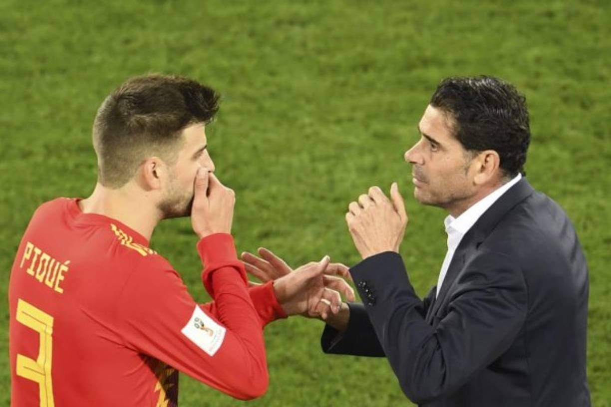Gerard Piqué se tapa la boca para dialogar con el entrenador de España, Fernando Hierro.