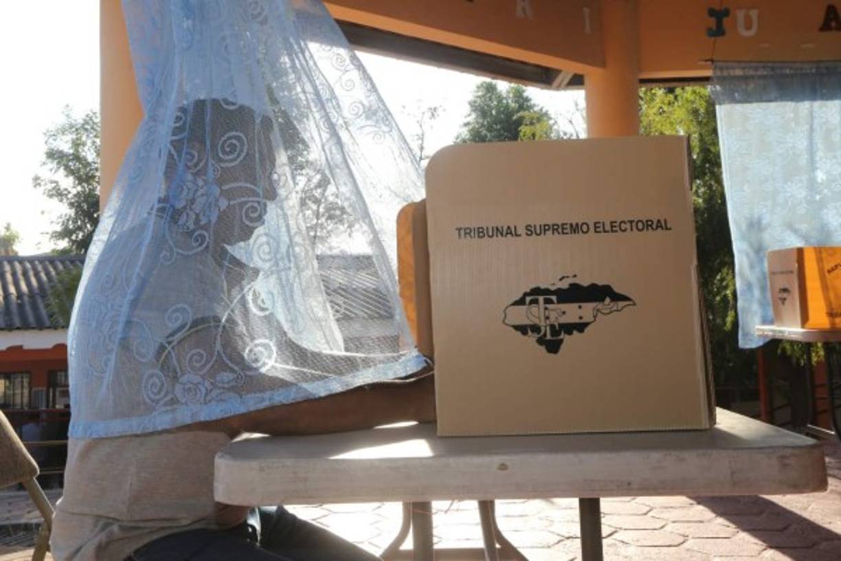 O estaba al aire libre o se estaba protegiendo de las picaduras de los mosquitos, lo cierto es que este hondureño se aseguró que nadie observara por quien votaba ni que lo picaran ningún insecto.