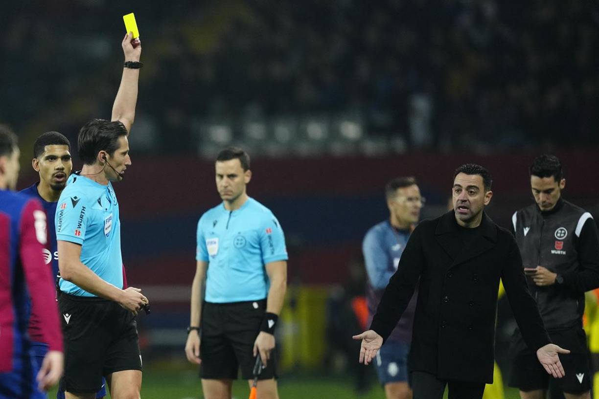 El árbitro José Luis Munuera Montero le muestra tarjeta amarilla a Xavi Hernández.