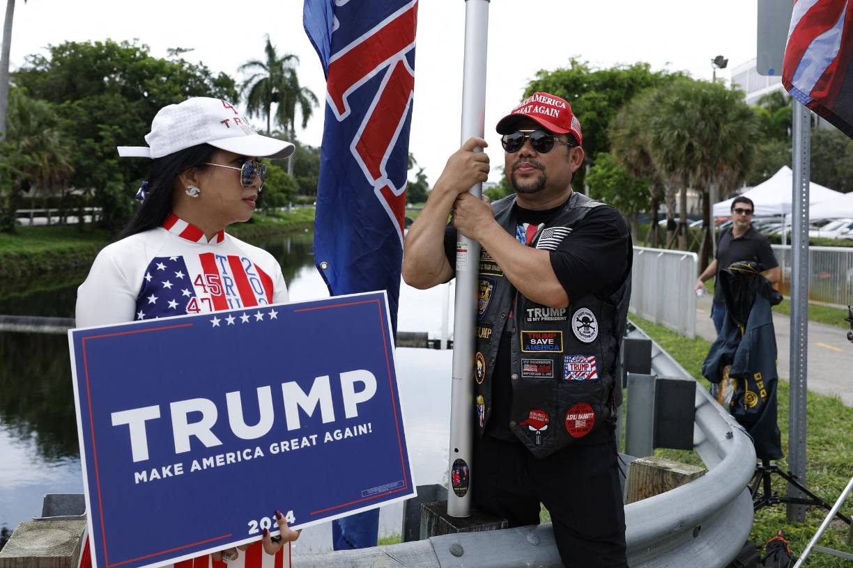 Con carteles con leyendas como “I stand with Trump” (Estoy con Triup), decenas de partidarios del expresidente se reunieron este para apoyarlo cerca de la entrada del campo de golf Trump National Doral Miami, en Doral, donde también se presentaron detractores del exmandatario.
