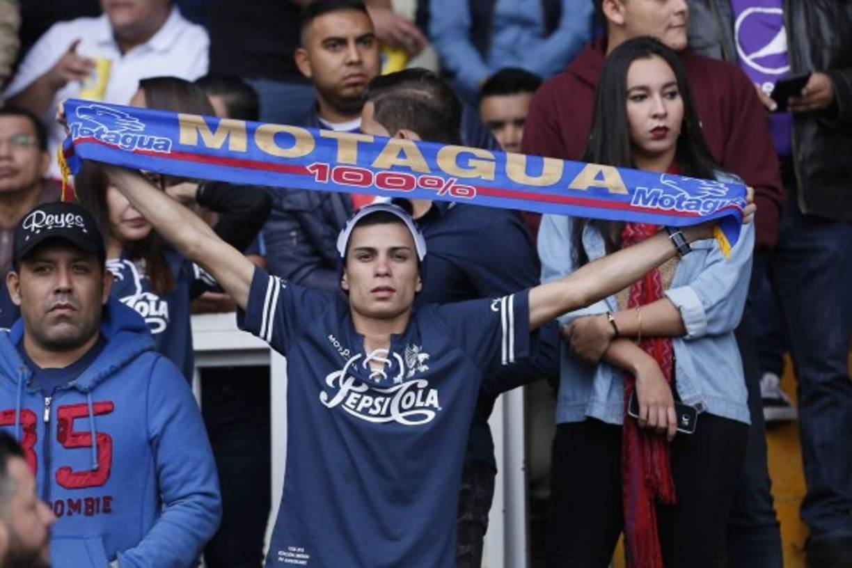 Un aficionado del Motagua alzando una bufanda de su equipo.