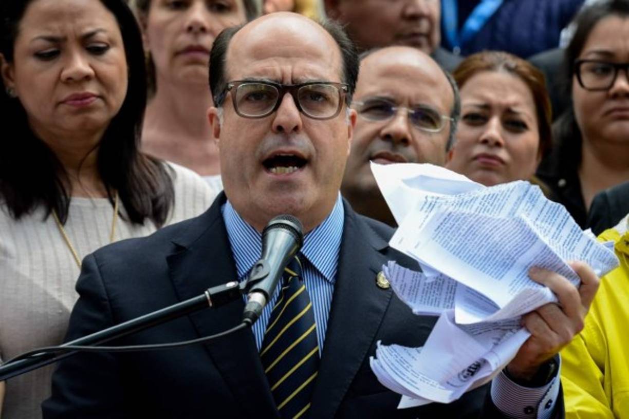 The president of Venezuela's National Assembly Julio Borges, holds a tore copy of a sentence from Venezuela's Supreme Court granting itself legislative powers, as he speaks during a press conference in Caracas on March 30, 2017.<br/>Venezuela's Supreme Court took over legislative powers Thursday from the opposition-majority National Assembly, whose speaker accused leftist President Nicolas Maduro of staging a 'coup.' / AFP PHOTO / FEDERICO PARRA