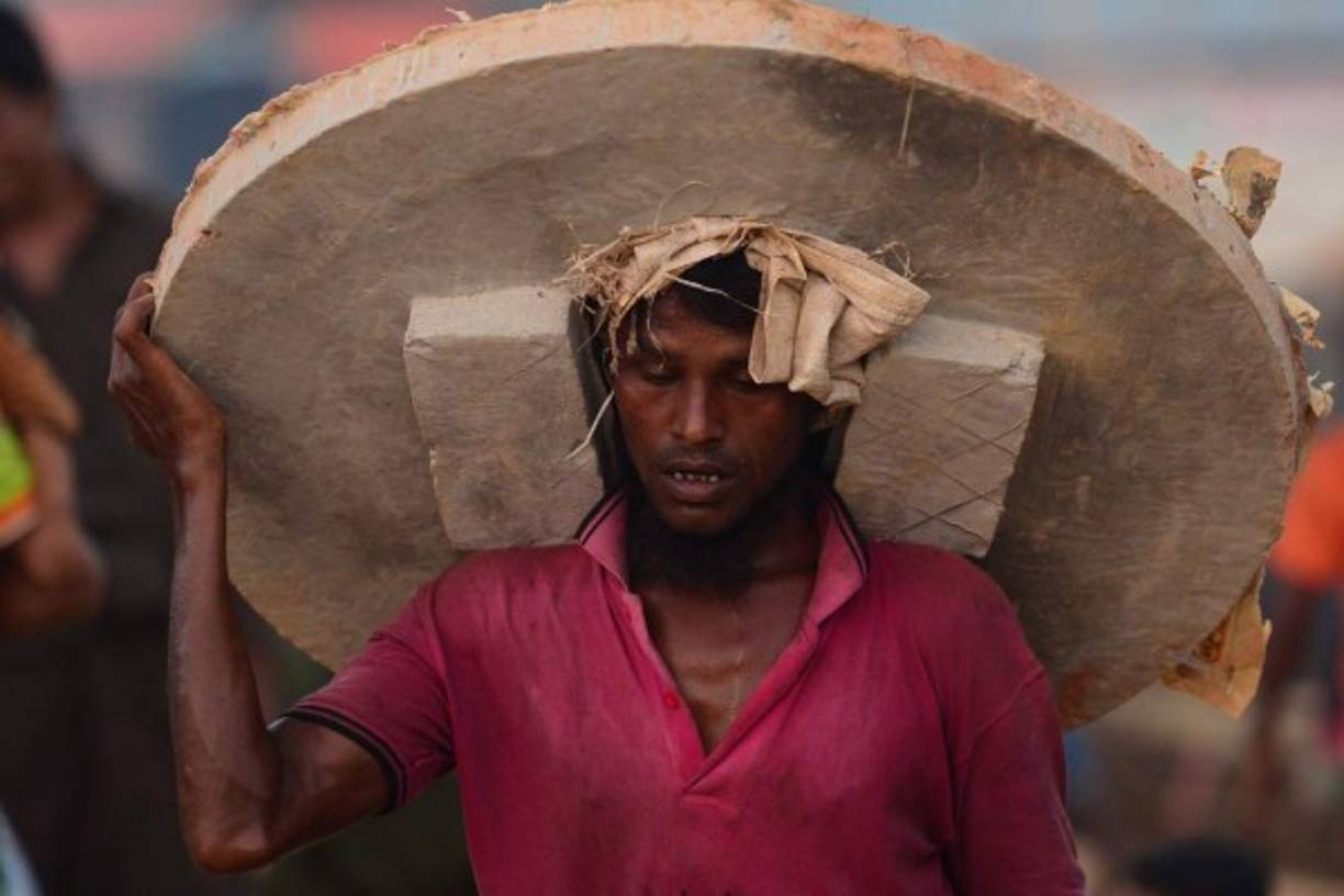 Bangladés. La vida en el exilio. Un refugiado rohingyá carga un anillo de alcantarilla en el campo de refugiados de Hakimpara.