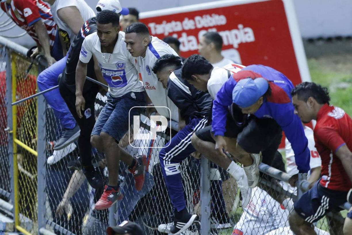 Aficionados olimpistas se saltaron el alambrado del sector preferencial para buscar a los hinchas del Motagua.