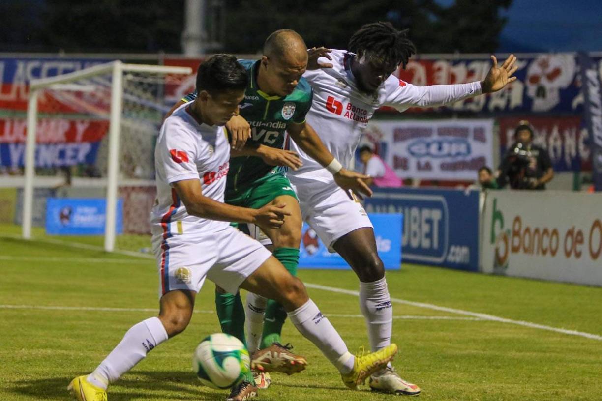 El delantero colombiano Edis Ibargüen, del Marathón, luchando por el balón con José Mario Pinto y José García, del Olimpia.