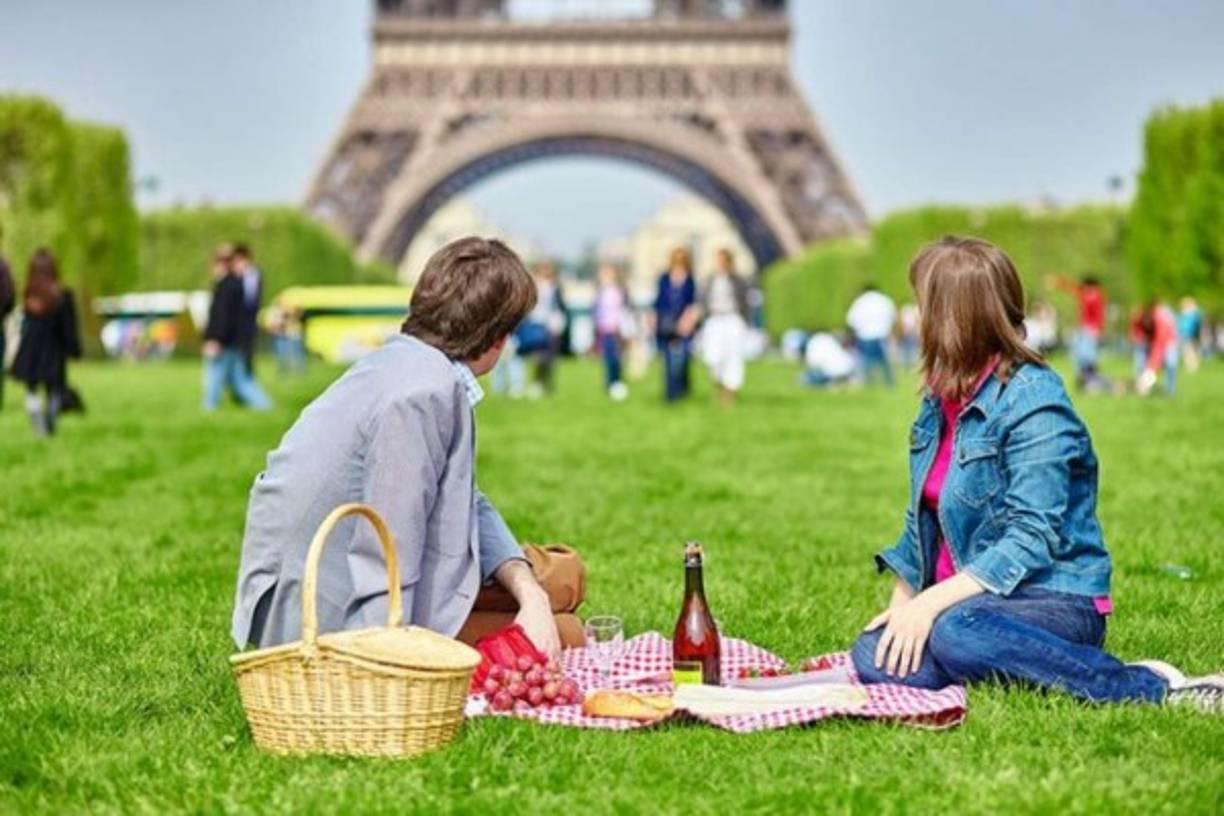 Sentarse a un picnic al lado de la Torre Eiffel en Paris.