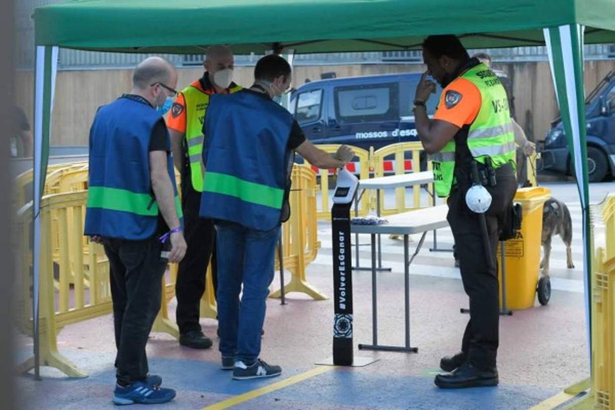 Los periodistas controlan su temperatura en la entrada del estadio Camp Nou, antes del partido.
