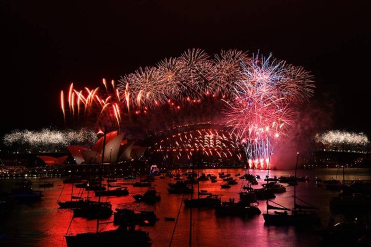 Los fuegos artificiales de Nochevieja estallan sobre el icónico Harbour Bridge y la Ópera (L) de Sydney durante el espectáculo de fuegos artificiales