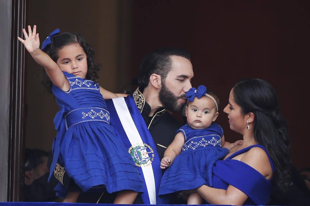 El presidente de El Salvador, Nayib Bukele, acompañado de su esposa, Gabriela Rodríguez, y de sus hijas saluda a los asistentes a la ceremonia de investidura para su segundo mandato, el 1 de junio. 
