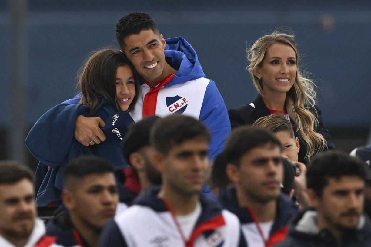 Luis Suárez con su hija Delfina y su esposa Sofia Balbi observando un video en su presentación.