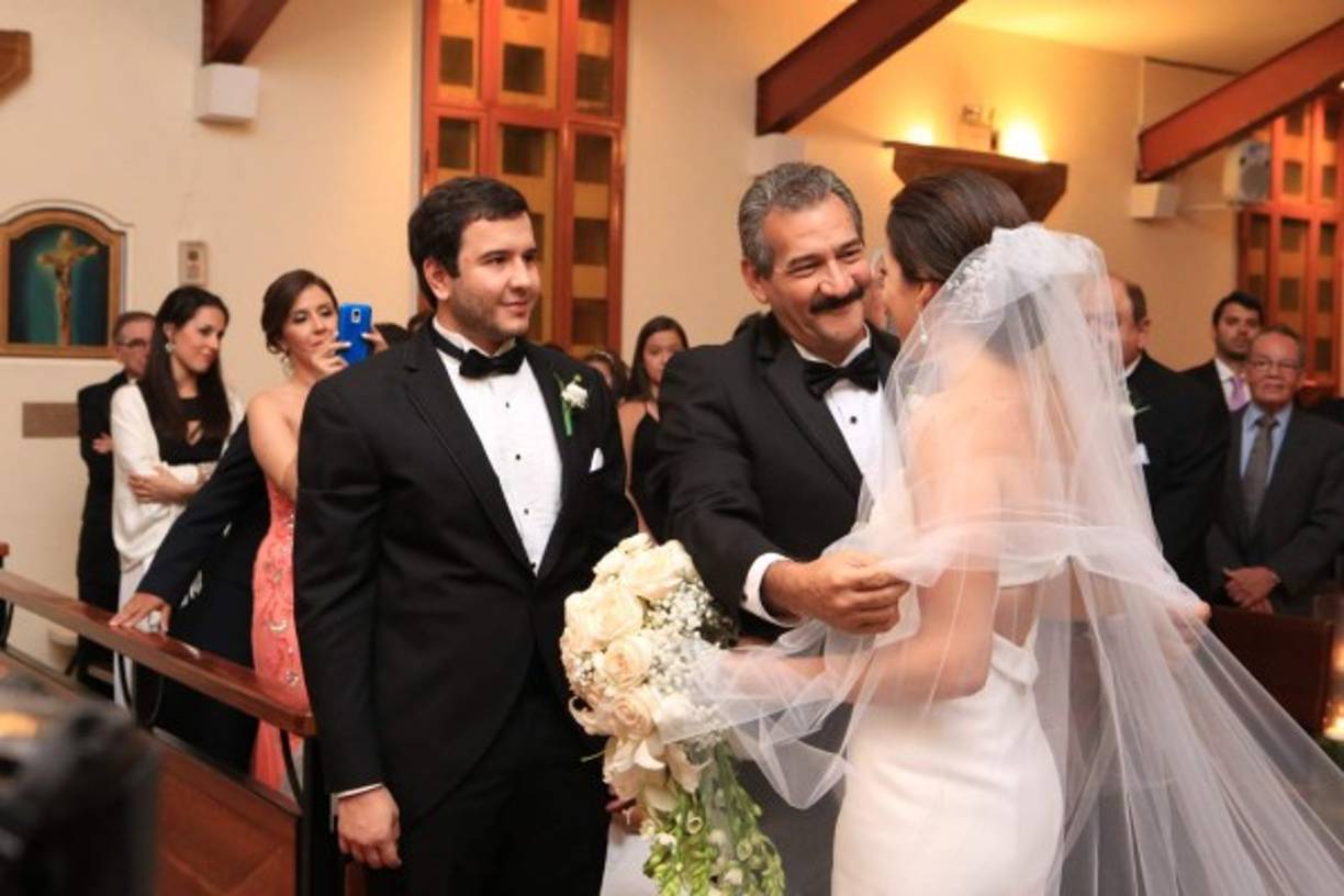 El orgulloso padre de la novia al entregarla a su ahora esposo ante el altar.