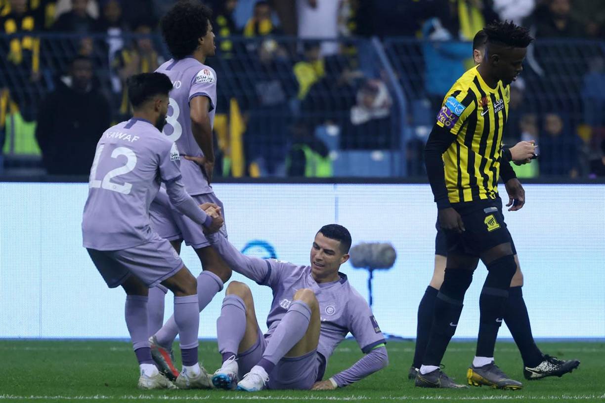 CR7 es ayudado por un compañero a levantarse tras la falta que sufrió.