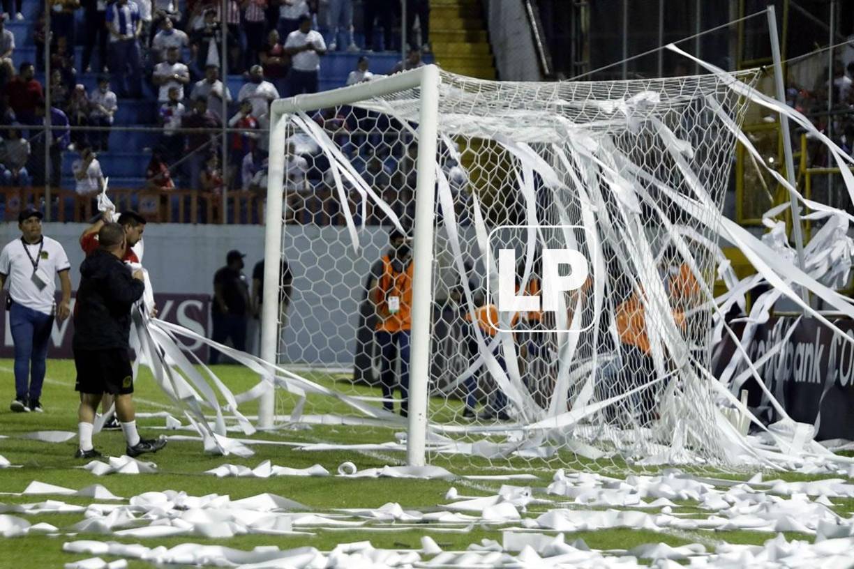 Miembros del staff del Olimpia tuvieron que sacar los papeles del campo antes del inicio del partido.
