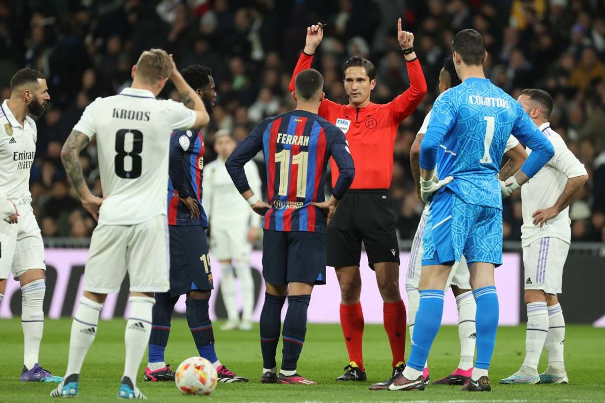 El árbitro José Luis Munuera Montero al momento de ser avisado por el VAR para validar el gol del Barcelona.