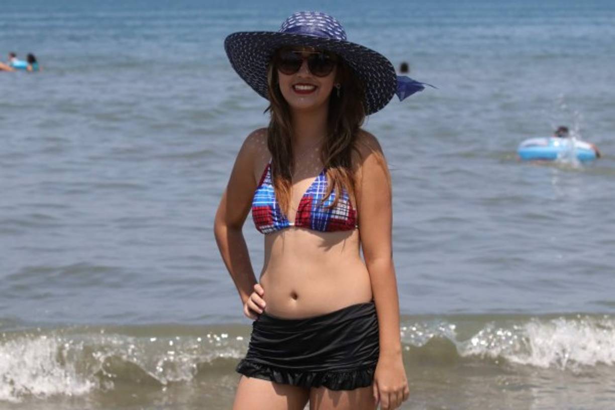 Una bella joven se pasea por la playa.