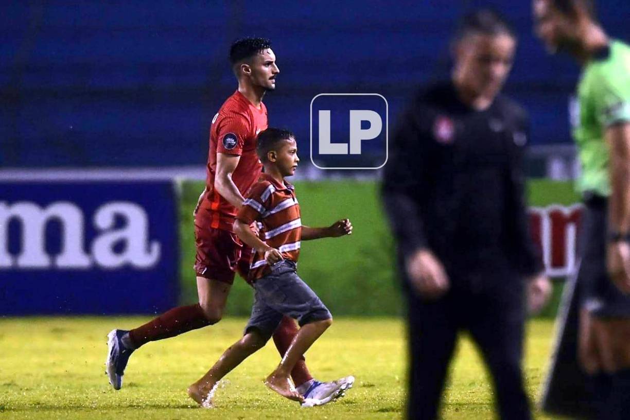 El canadiense Estephen Eustaquio sacando a un niño que se metió al campo del Olímpico.