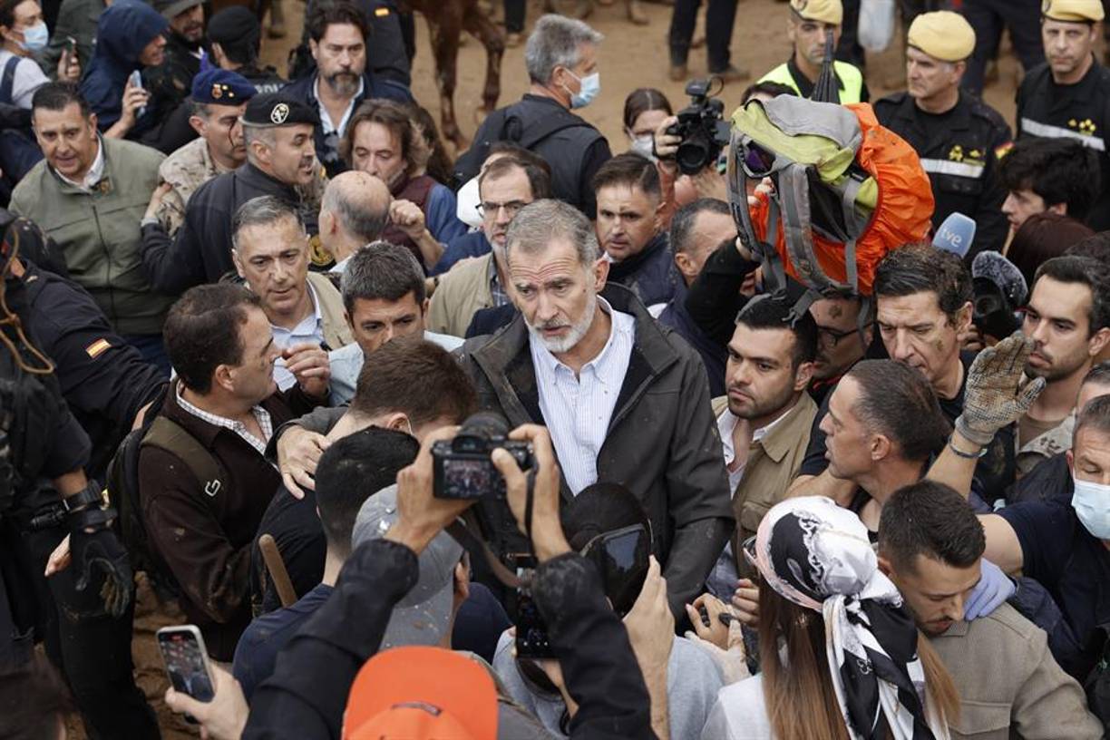 Felipe VI rodeado de elementos de la prensa y su equipo de seguridad.
