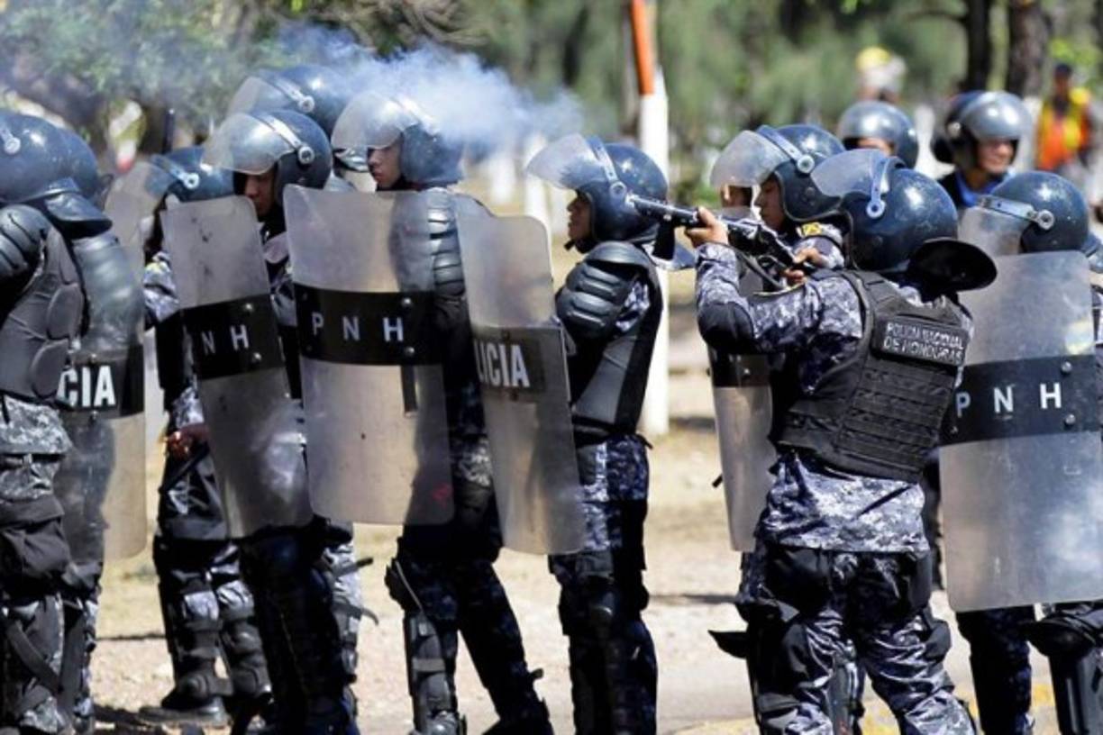 Estudiantes universitarios se enfrentan a la Policía a la Policía para exigir justicia cuando se cumple un año del asesinato de la líder indígena y ambientalista Berta Cáceres, en Tegucigalpa (Honduras). EFE/Gustavo Amador