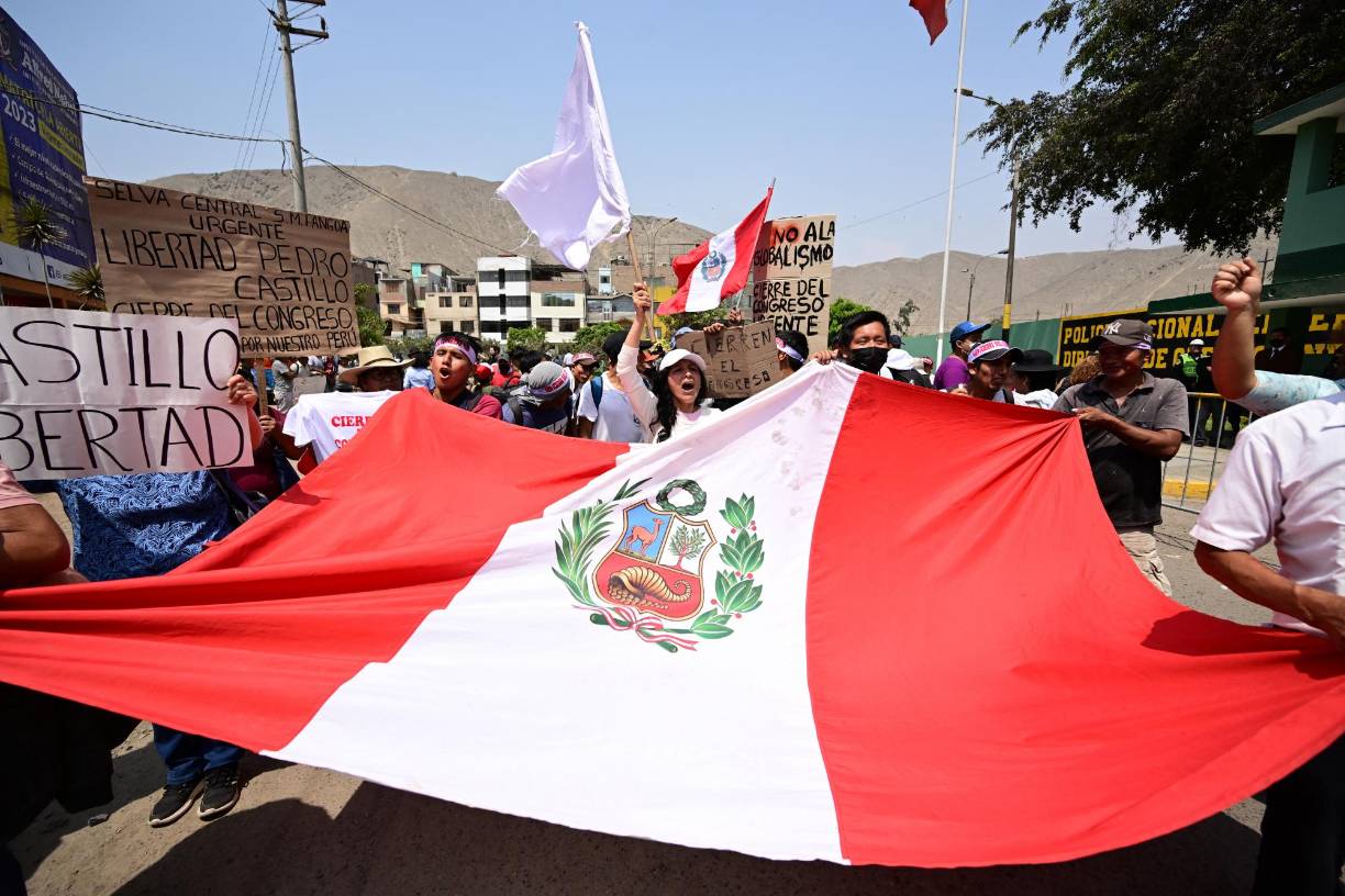 Supporters of Peruvian former President Pedro Castillo hold a demonstration demanding his release outside the police dependence DIROES in Ate, east of Lima, where Castillo is being held, on December 14, 2022. - Former Peruvian President Pedro Castillo, accused of "rebellion" and "conspiracy", will continue to be detained at a police base after an appeals court declared his request for freedom unfounded on Tuesday while protests that have left seven dead and 200 injured continue. (Photo by MARTIN BERNETTI / AFP)