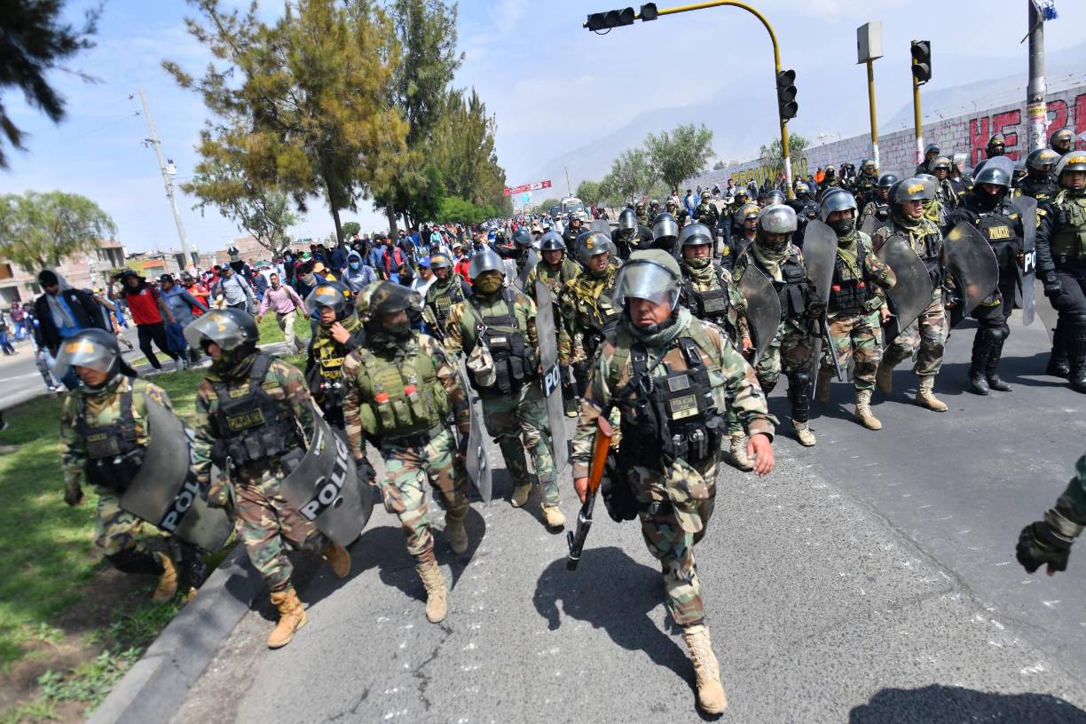 Supporters of former President Pedro Castillo march to the center of the city of Arequipa, Peru, with a strong police contingent demanding the closure of Congress and the release of Castillo, on December 14, 2022. - Former Peruvian President Pedro Castillo, accused of "rebellion" and "conspiracy", will continue to be detained at a police base after an appeals court declared his request for freedom unfounded on Tuesday while protests that have left seven dead and 200 injured continue. (Photo by Diego Ramos / AFP)