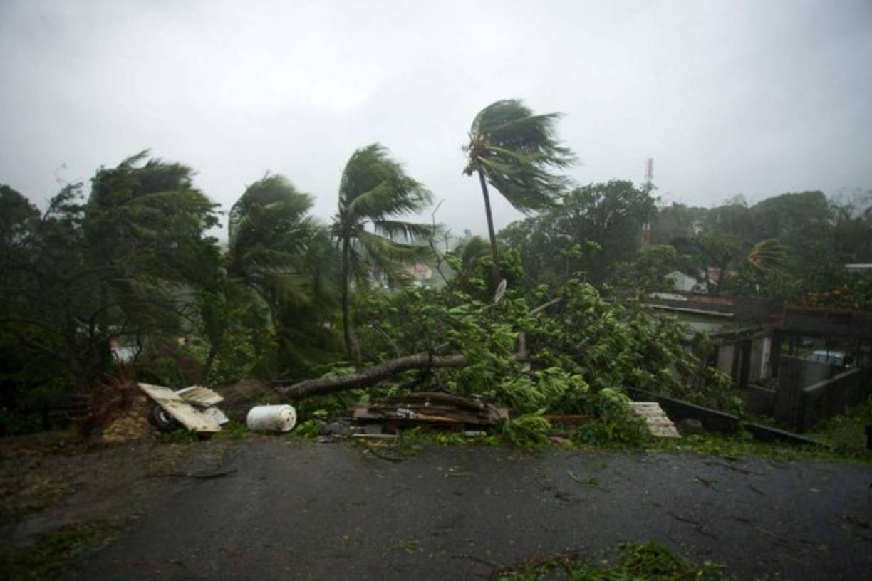 A picture taken on September 19, 2017 shows the powerful winds and rains of hurricane Maria battering the city of Petit-Bourg on the French overseas Caribbean island of Guadeloupe.<br/>Hurricane Maria strengthened into a 'potentially catastrophic' Category Five storm as it barrelled into eastern Caribbean islands still reeling from Irma, forcing residents to evacuate in powerful winds and lashing rain. / AFP PHOTO / Cedrik-Isham Calvados