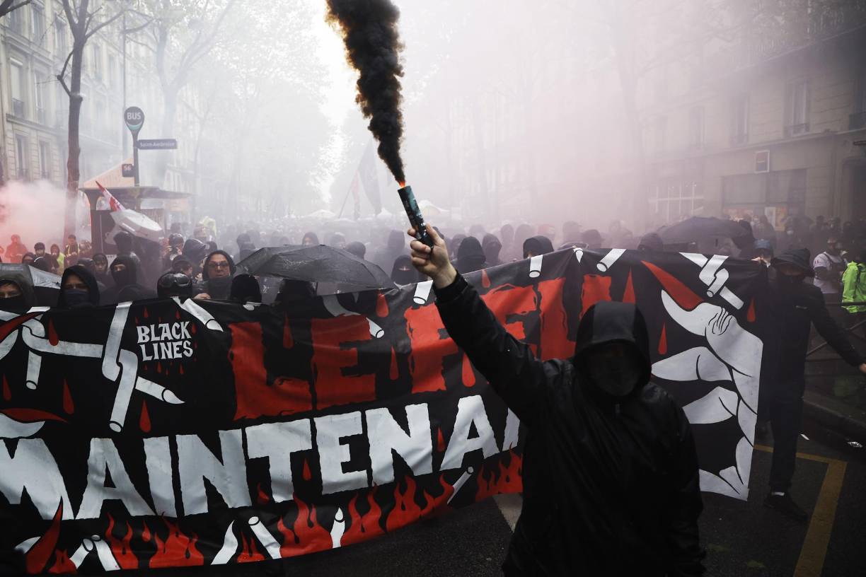 Paris (France), 01/05/2023.- A member of the anarchist trade union CNT (National Confederation of Work) lights a black fumigant during the annual May Day march in Paris, France, 01 May 2023. Despite the Constitutional Council's adoption of the law on 14 April raising the retirement age in France from 62 to 64 years old, protests against pension reform are being held in France on this International Workers' Day. Following the filing of a new appeal by the left-wing senators, a new decision is expected on May 3. (Protestas, Francia) EFE/EPA/CHRISTOPHE PETIT TESSON 