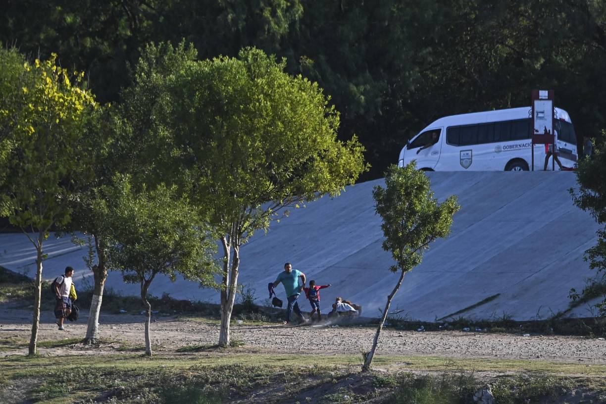 En la orilla mexicana, unas camionetas vienen y van durante horas para descargar a las personas que acabarán cruzando al otro lado. 
