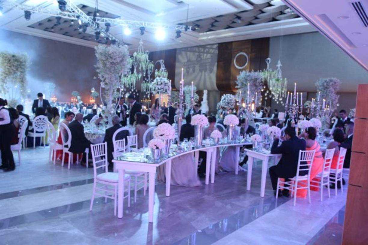 El blanco y las luces led crearon efectos audaces con primavera incluída. Las mesas de formas curvas y los arreglos de rosas y flores silvestres se fusionaron con candelabros y velas.