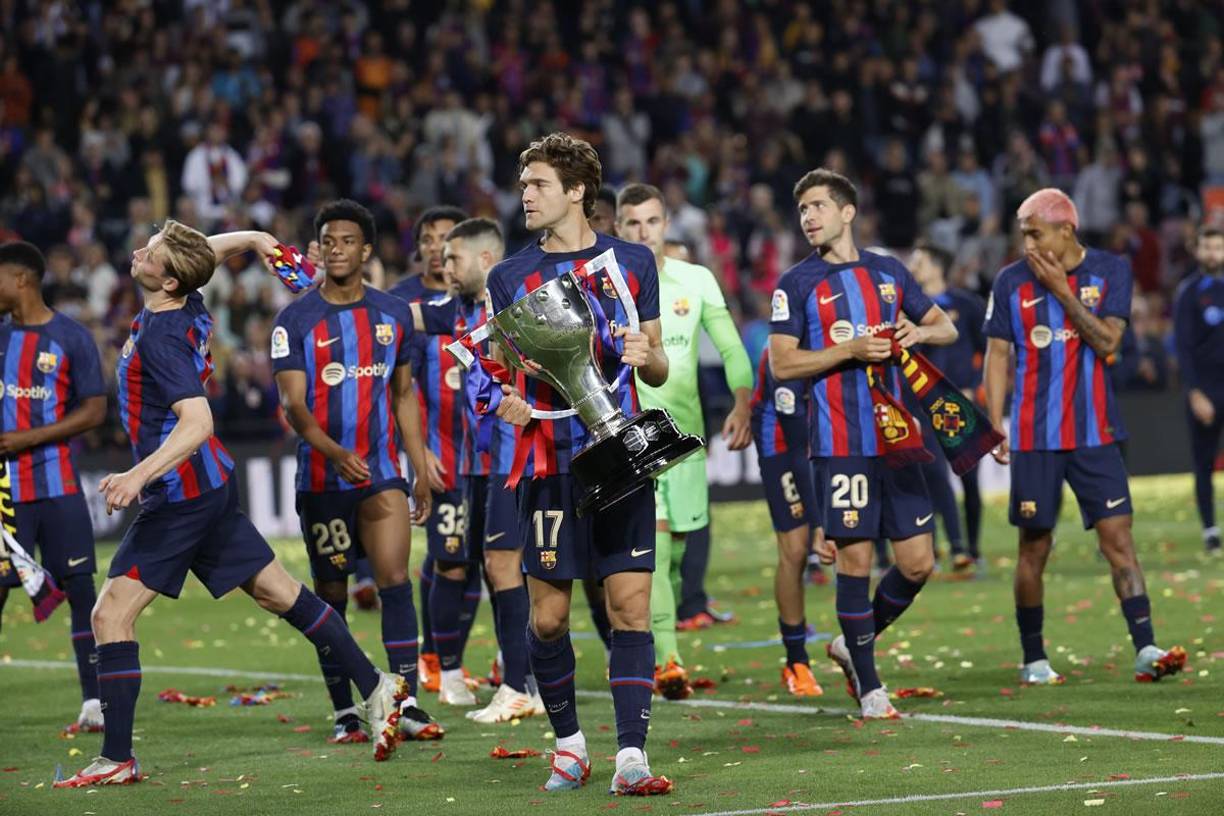 Marcos Alonso recorriendo el campo con el trofeo de campeón en sus manos.