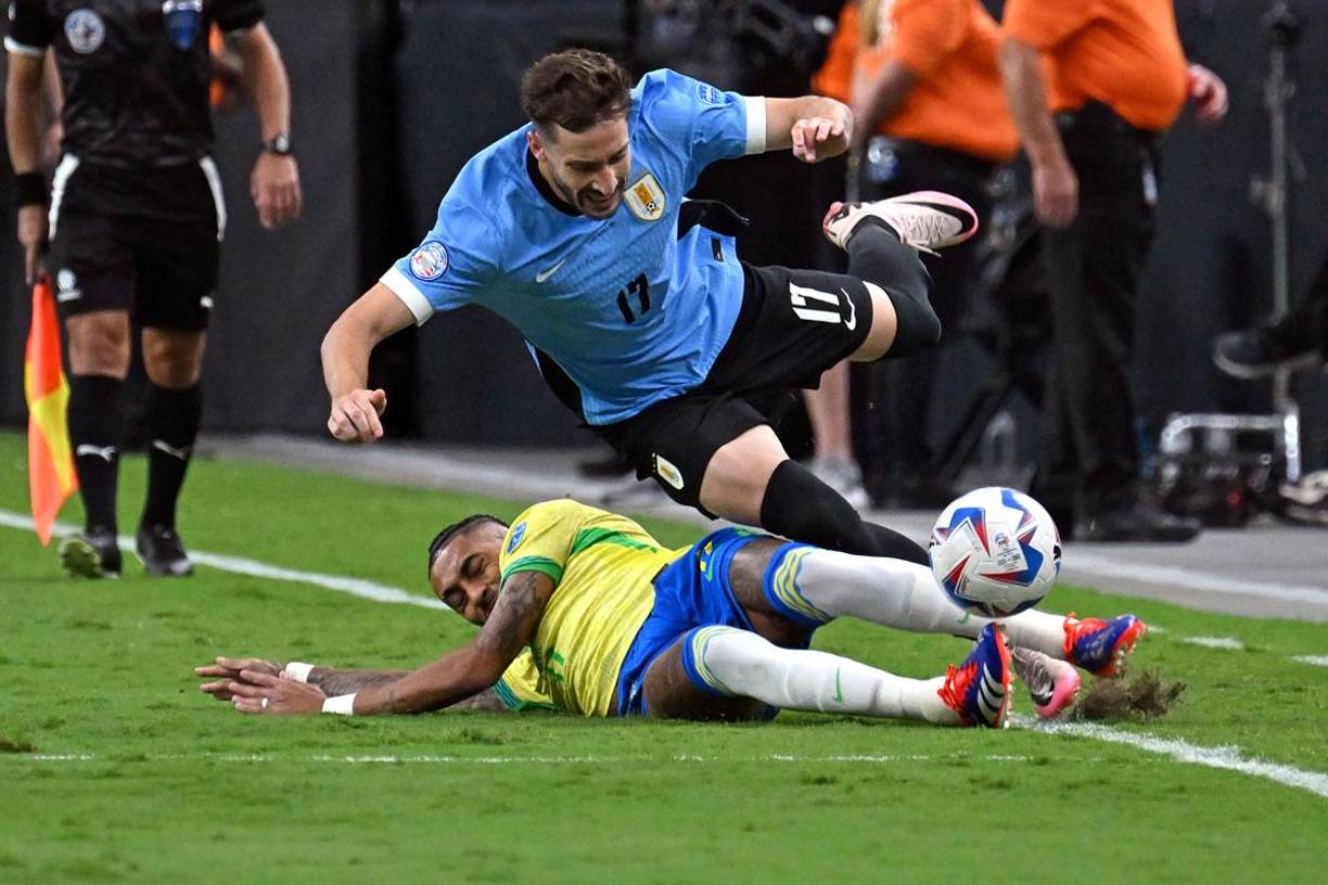 Fue un partido muy disputado. Raphinha se barre para sacarle el balón al uruguayo Matías Viña.