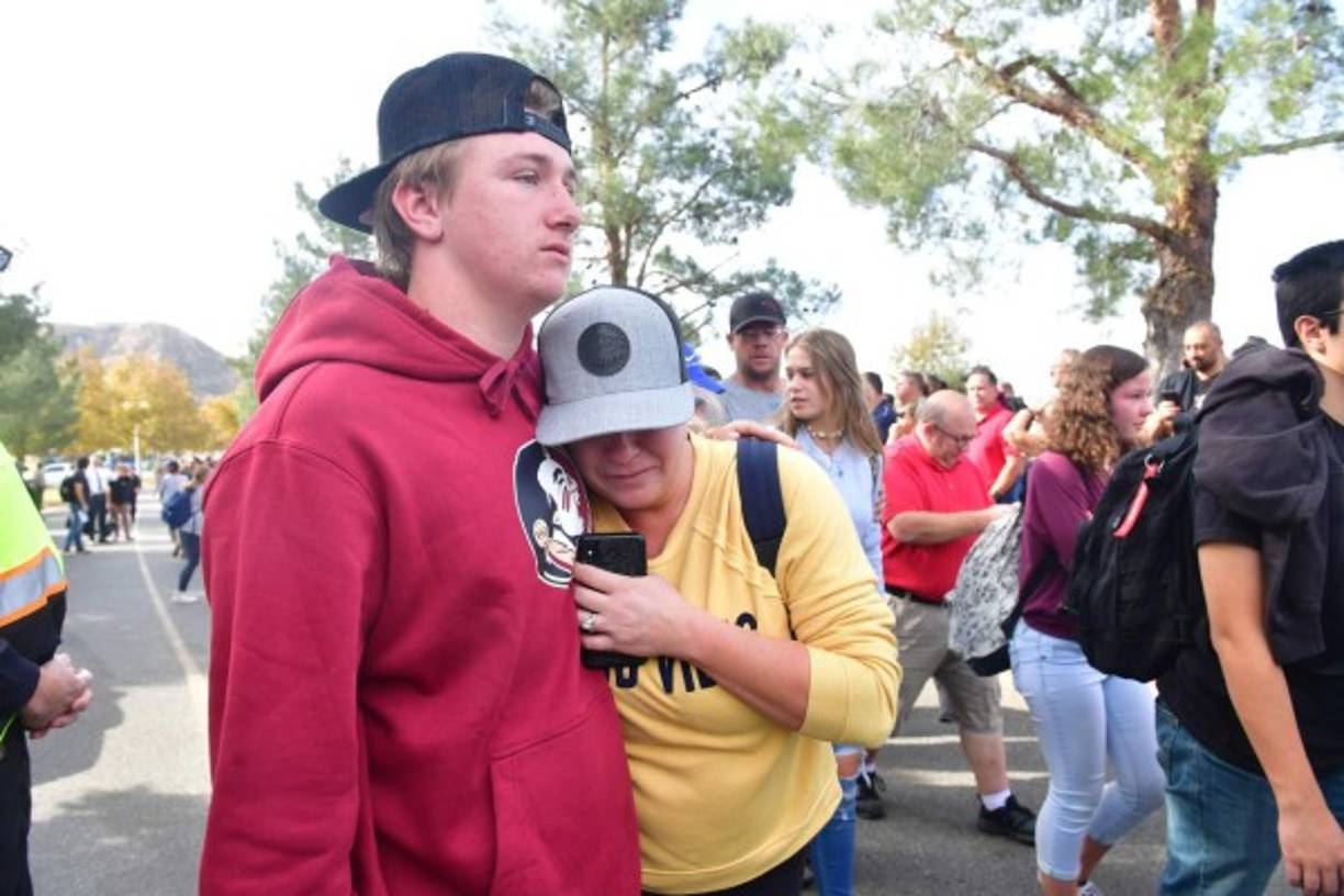 People react near Central Park after a shooting at Saugus High School in Santa Clarita, California on November 14, 2019. - At least four people were injured in a shooting at a high school north of Los Angeles Thursday, triggering a police hunt for the suspect who was later taken into custody.One female was killed Thursday, hospital officials said. The suspect was in custody and taken to a hospital for treatment, while at least three others were injured in the shooting at Saugus High School in Santa Clarita, 40 miles (65 kilometers) north of Los Angeles.'One female deceased patient. Two critical male patients. One male patient in good condition,' tweeted the nearby Henry Mayo Hospital in Valencia.No further details of the deceased were provided. (Photo by Frederic J. BROWN / AFP)