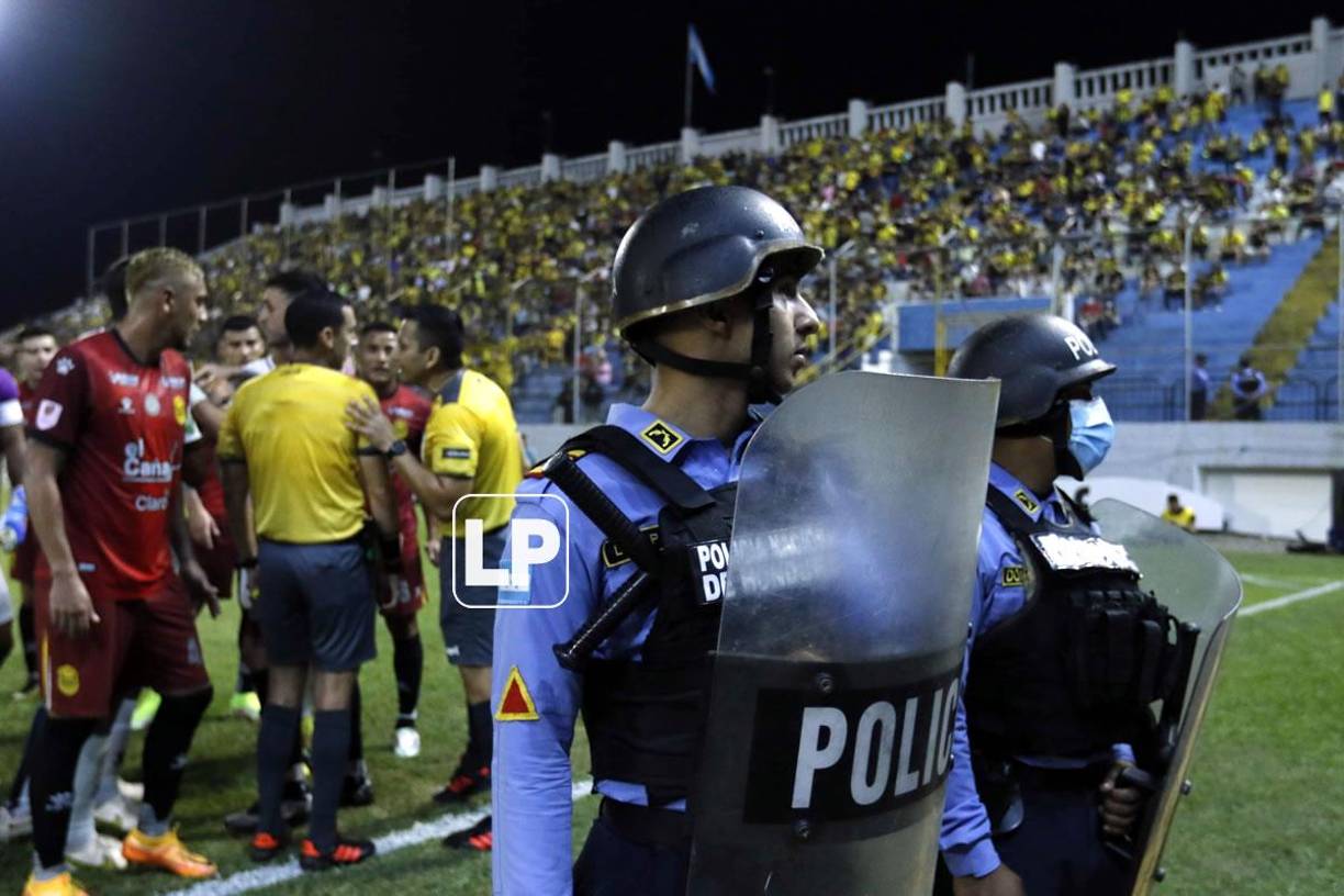 Jugadores del Real España se acercaron a reclamar a los árbitros mexicanos, mientras la Policía Nacional resguardaba la zona.