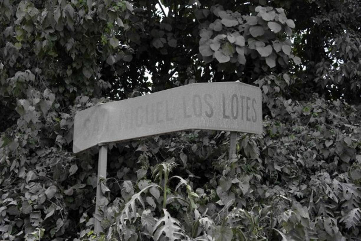 View of a roadside sign covered in ashes at San Miguel Los Lotes, a village in Escuintla Department, about 35 km southwest of Guatemala City, on June 4, 2018, a day after the eruption of the Fuego Volcano.<br/>Rescue workers Monday pulled more bodies from under the dust and rubble left by an explosive eruption of Guatemala's Fuego volcano, bringing the death toll to at least 62. / AFP PHOTO / JOHAN ORDONEZ
