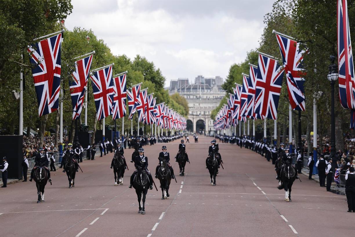 La solemne procesión transcurre a paso lento y en orden casi perfecto por The Mall -que une el palacio y Whitehall, donde se ubican algunos edificios gubernamentales-, engalanada con grandes banderas británicas.