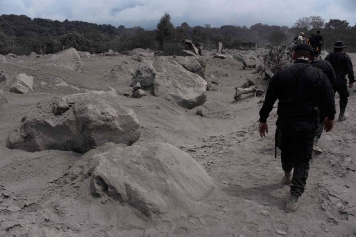 Police officers search for victims in the village of San Miguel Los Lotes, in Escuintla department, about 35 km southwest of Guatemala City, two days after the eruption of the Fuego Volcano, on June 5, 2018.<br/>Rescue workers pulled more bodies from under the dust and rubble left by an explosive eruption of Guatemala's Fuego volcano, bringing the death toll to at least 69. / AFP PHOTO / Johan ORDONEZ