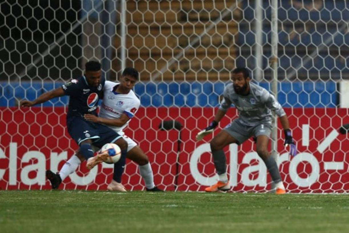 Carlos Pineda sujeta a Reinieri Mayorquín que dispara desviado de la portería de Edrick Menjívar. Fue una ocasión muy clara del Motagua en la primera parte.