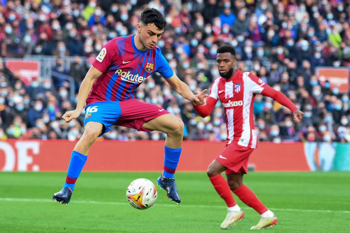 Pedri bajando el balón ante la mirada de Thomas Lemar.