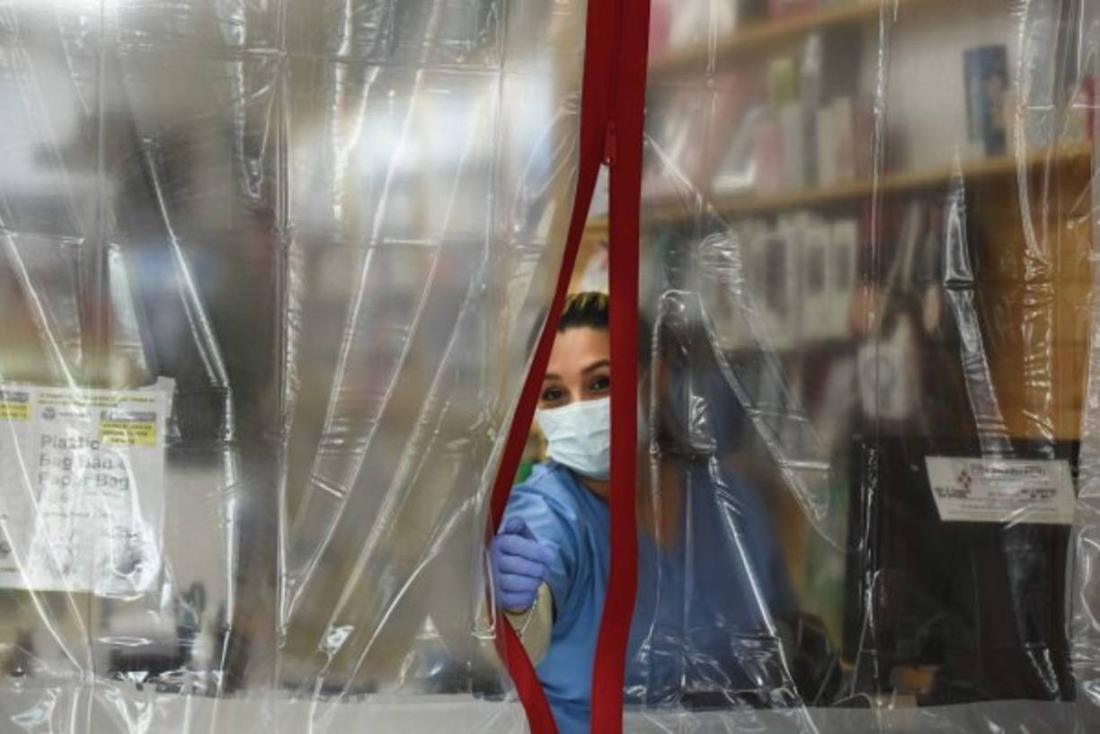 NEW YORK, NEW YORK - MAY 22: A United States Postal Service (USPS) worker wearing a protective mask and gloves pushes a cart across the street in Midtown Manhattan during the coronavirus pandemic on May 22, 2020 in New York City. COVID-19 has spread to most countries around the world, claiming over 336,000 lives and infecting over 5.1 million people. Dia Dipasupil/Getty Images/AFP