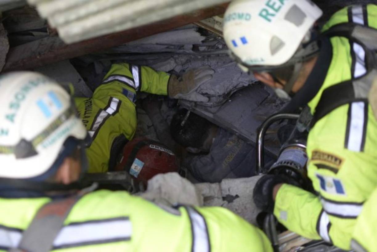 Miembros del equipo de rescate intentan sacar a una de las víctimas de los escombros de una casa tras el deslave de tierra en Guatemala.