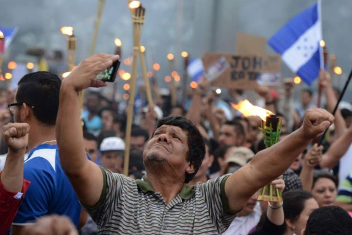 Un capitalino se toma una selfie durante la marcha de las antorchas en Tegucigalpa.