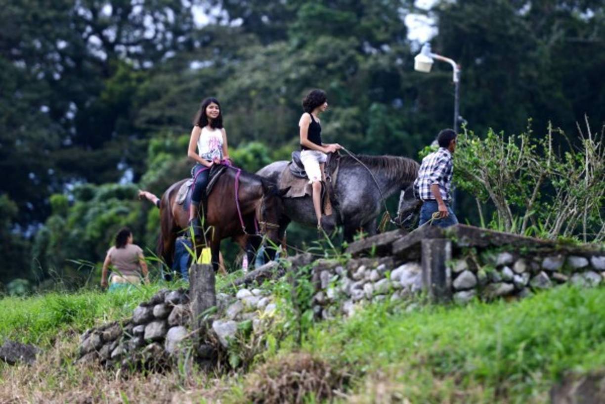 Turistas pasean a caballo en las orillas del Lago de Yojoa. AFP