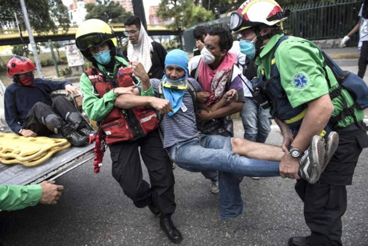 Los servicios de emergencia trataban de ayudar a los manifestantes heridos durante los disturbios.