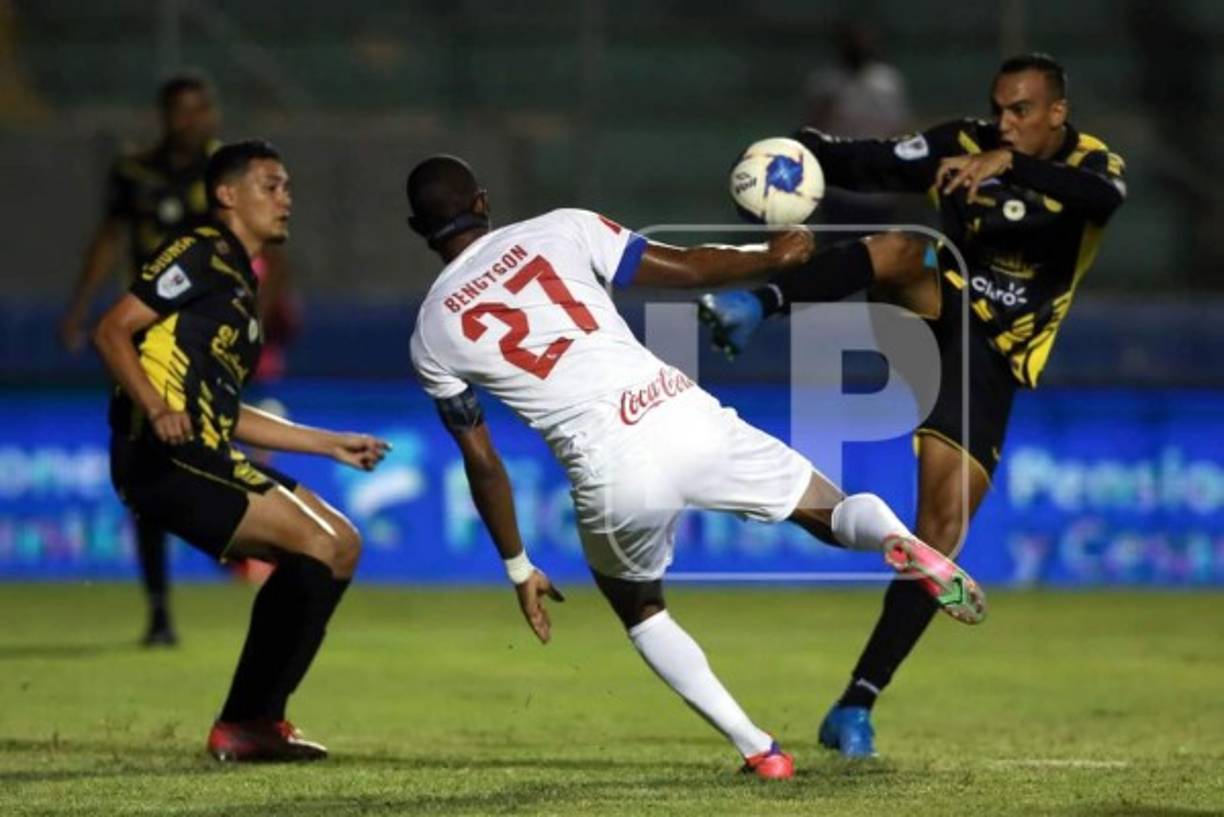 Devron García levanta bien alto la pierna para quitarle el balón a Jerry Bengtson en el clásico en el estadio Nacional.