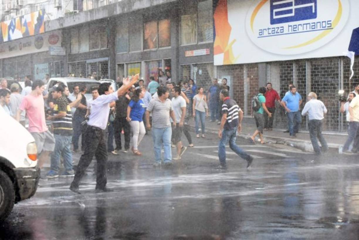 Agentes antidisturbios que acordonan el edificio, en el centro de Asunción, dispararon balines de goma a manifestantes.<br/>