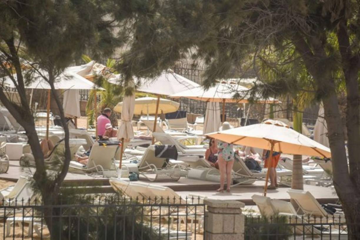 Los turistas toman hoy el sol en el Hotel H10 Costa Adeje Palace en La Caleta, donde cientos de personas fueron confinadas después de que un turista italiano fue hospitalizado con un presunto caso de coronavirus.
