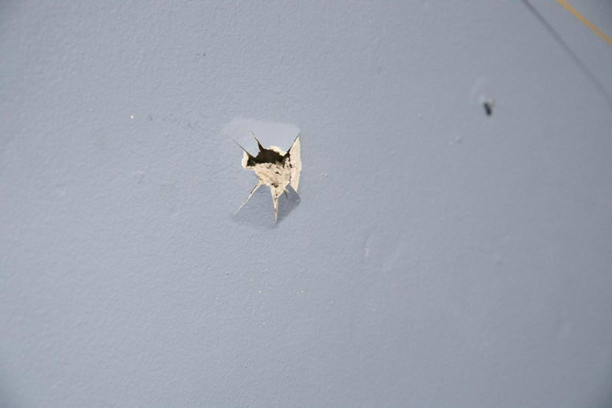 Imágenes difundidas en redes sociales muestran orificios de bala en varias paredes de la casa.