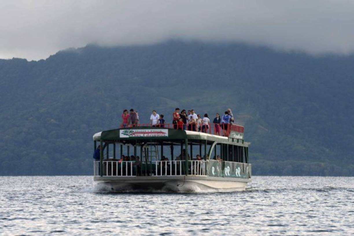 Un barco con turistas navega a través del Lago de Yojoa. AFP