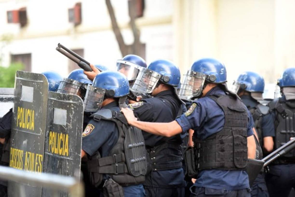 Riot police agents crack down on a protest against the approval of a constitutional amendment for presidential reelection, outside Congress in Asuncion, on March 31, 2017.<br/>Ruling Colorado party senators and their allies, in a so-called 'parallel Senate', unexpectedly approved an amendment Friday that would allow President Horacio Cartes to run for reelection in 2018, triggering protests that led to clashes between opposition demonstrators and the police. / AFP PHOTO / NORBERTO DUARTE
