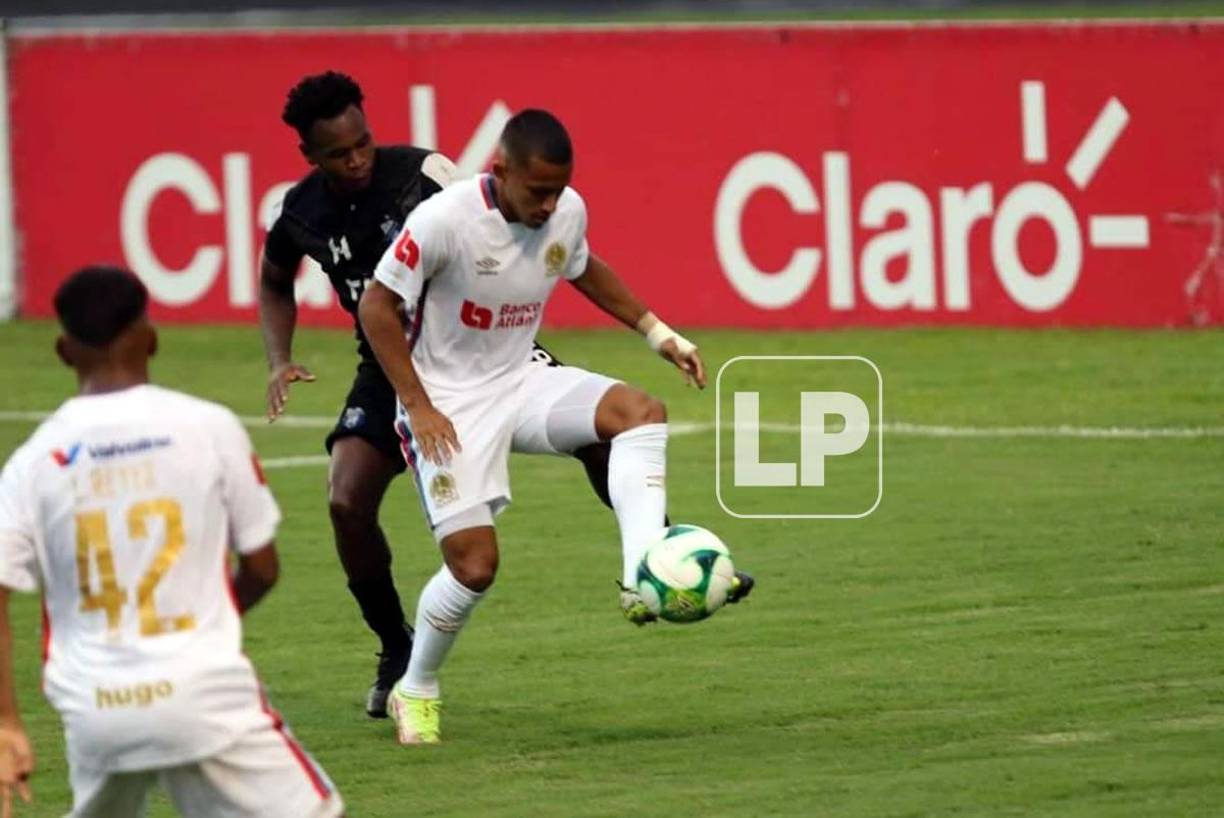 Edwin Rodríguez controlando el balón ante la marca de un defensa del Honduras Progreso.
