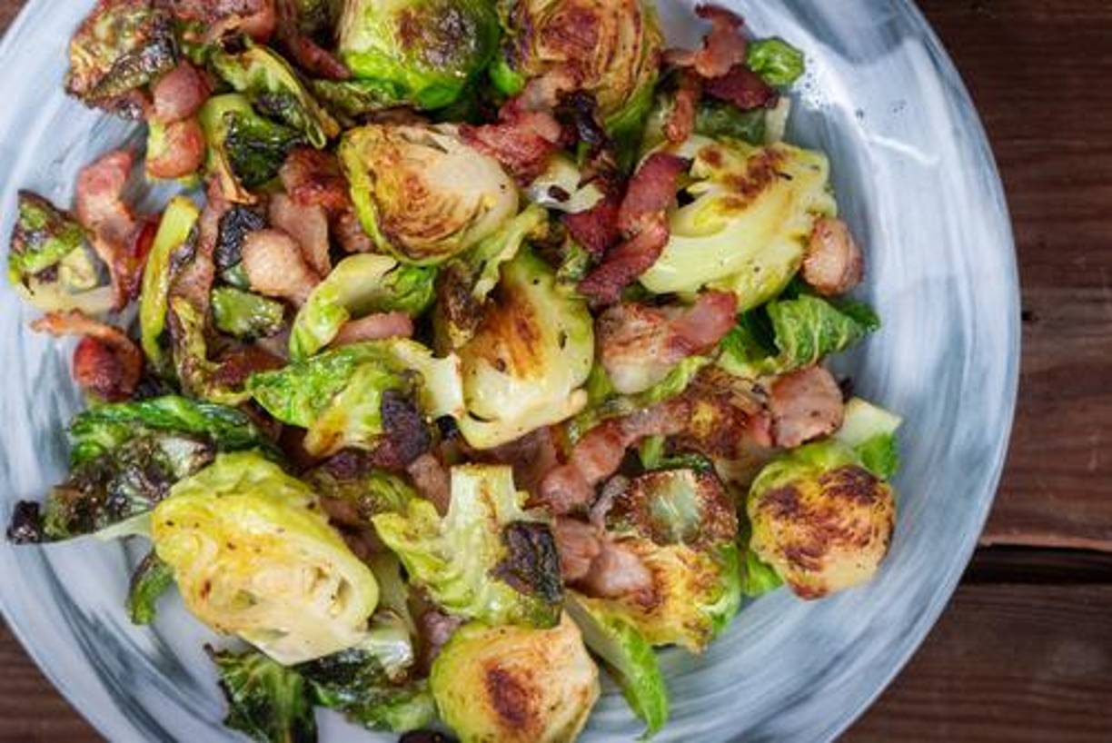 7. Coles de bruselas asadas: Las coles de Bruselas asadas con tocino son una guarnición sabrosa y crujiente. Asa las coles con trozos de tocino, aceite de oliva, sal y pimienta hasta que estén doradas.